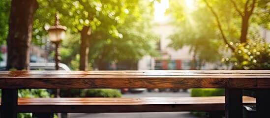 A simple wooden bench placed in the center of a peaceful park surrounded by greenery under the shade of trees - obrazy, fototapety, plakaty