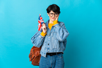 Woman holding an United Kingdom flag over isolated background frustrated and covering ears