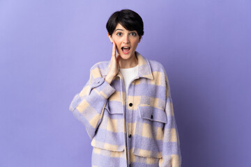 Woman with short hair isolated on purple background with surprise and shocked facial expression