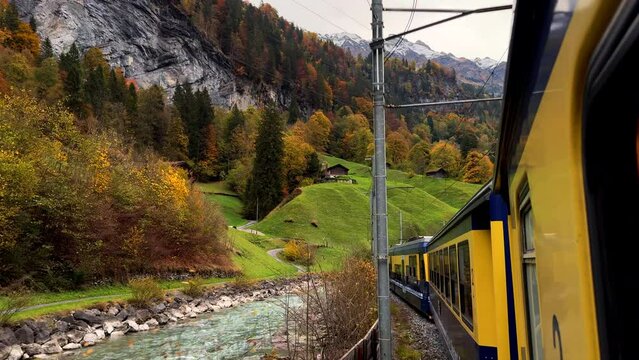 Switzerland Swiss Alps train ride Grindelwalk Jungfrau Interlaken to Lauterbrunnen late October November autumn fall colors river late afternoon Bernese Overland Thun Bern region snow peak glacier