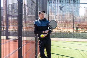 paddle player resting against the wall entertained by the ball