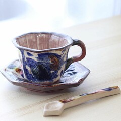 青い魚のような模様が描かれたやちむんのティーカップとソーサーとスプーン