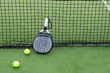 paddle tennis racket and balls on court