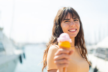 Young woman with a cornet ice cream at outdoors with happy expression