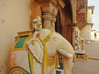 Tiger sculptures under big elephant figures at palace entrance