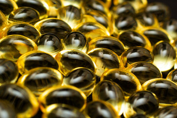 Macro Close up of Omega 3 gel capsule on a reflective black background - obrazy, fototapety, plakaty