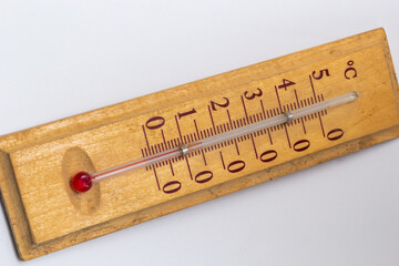 room thermometer on a wooden base close up on a white background. Celsius degree scale - obrazy, fototapety, plakaty