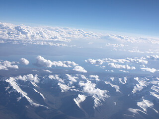 An aerial view of blue sky, white clouds and snow-capped mountains © jing