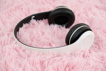 White headphones on pink carpet background.	