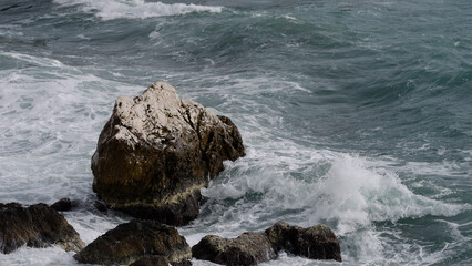 stormy mediterranean sea crushing over rock