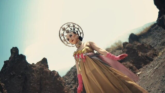 Ethereal woman in avant-garde attire posing in a rugged landscape