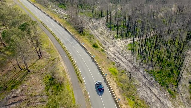 Porsche driving along the dune filmed with a drone