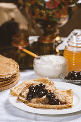 Pancakes with black currant jam on a plate,  Russian style