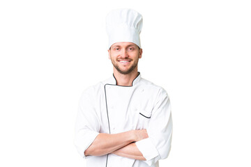 Young caucasian chef over isolated chroma key background keeping the arms crossed in frontal...
