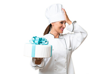 Middle-aged chef caucasian woman with a big cake over isolated background has realized something and intending the solution
