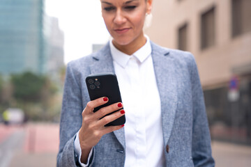  Portrait caucasian business woman using an app on her smartphone outdoors.