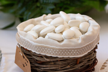 traditional sugared almonds in a rustic woven basket