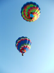 pair of hot air balloons drifting in the sky