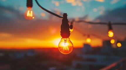 a string light bulbs at sunset on the rooftop - obrazy, fototapety, plakaty