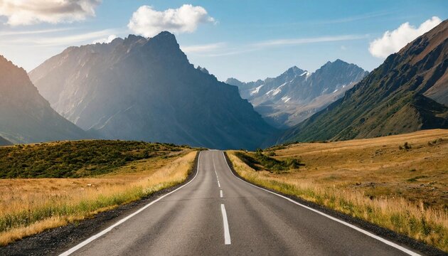 Road stretches through scenic mountains. Beauty of nature. Natural landscape. Cloudy sky.