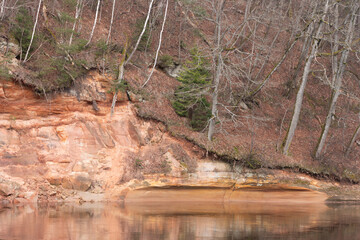 A beautiful sandstone cliffs at the river in Gauja National Park, Latvia. Springtime landscape of Northern Europe.