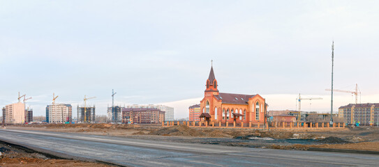 large construction site with a Catholic church in the background