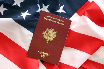 French passport on United States national flag background close up. Tourism and diplomacy concept