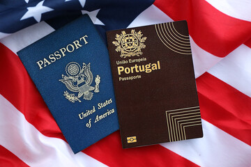 Passport of Portugal with US Passport on United States of America folded flag close up