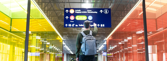 Man pointing at a sign in an airport