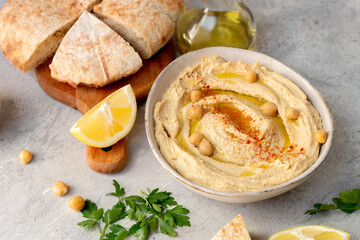 Traditional hummus with pita bread and paprika , lemon and olive oil
