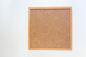 Blank cork board in wooden frame on white background with copy space in top view