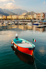 A fishing boat stands at the pier in Salerno against the background of urban buildings