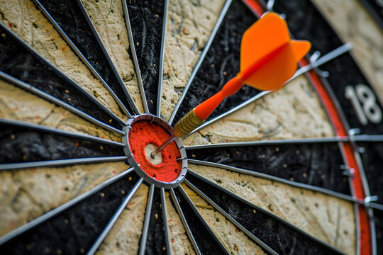 A close-up image of a vibrant orange dart successfully hitting the bullseye of a dartboard, symbolizing precision and achievement.
