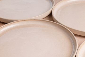 Beige ceramic dinner plates on a brown stone tabletop.