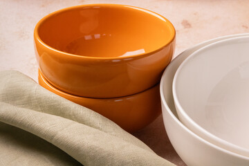 Orange and white bowls on a beige stone tabletop.