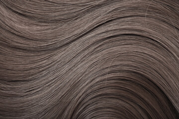 Blond hair close-up as a background. Women's long light brown hair. Beautifully styled wavy shiny...