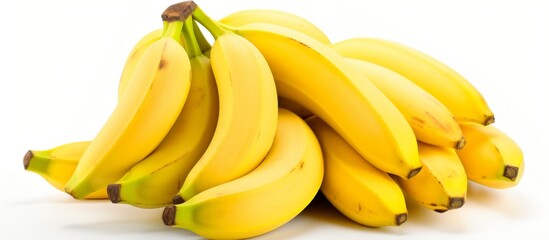 A bunch of bananas, a fruit from the cooking plantain plant in the banana family, sits on a white surface. Bananas are natural foods and considered a superfood - obrazy, fototapety, plakaty