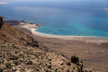 Views of the river between the island of La Graciosa and Lanzarote. Turquoise ocean. Blue sky with big white clouds. Caleta de Sebo. Village. Volcanoes. Lanzarote, Canary Islands, Spain