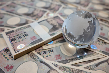大量の一万円札とガラスの地球儀　10,000 yen bills and a glass globe - obrazy, fototapety, plakaty