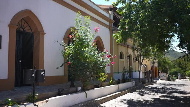 Beautiful exterior of white building with arched doorways in historical mining town of El Triunfo, Mexico.