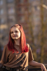 Fototapeta premium Portrait of a young red-haired girl outdoors in spring.
