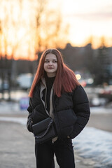 Portrait of a young red-haired girl outdoors in spring.