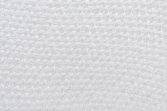 Texture of white mesh fabric. Background of light mesh fabric