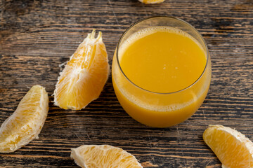 peeled juicy oranges and orange juice on the table