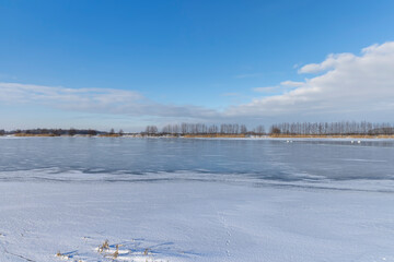 the lake is covered with ice in winter and sunny weather