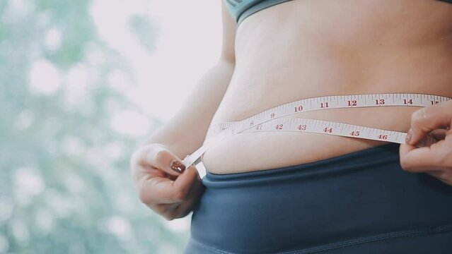Women body fat belly. Obese woman hand holding excessive belly fat. diet lifestyle concept to reduce belly and shape up healthy stomach muscle.