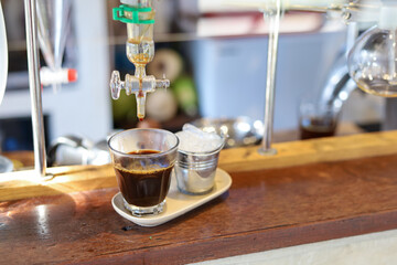 selective focus black coffee in a clear glass 1 shot obtained from liquid distillation equipment In...