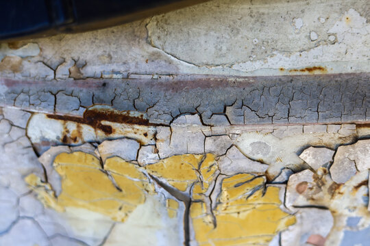 Selective focus on cracked and peeling paint surfaces on old cars. The background image looks old. vintage and classic