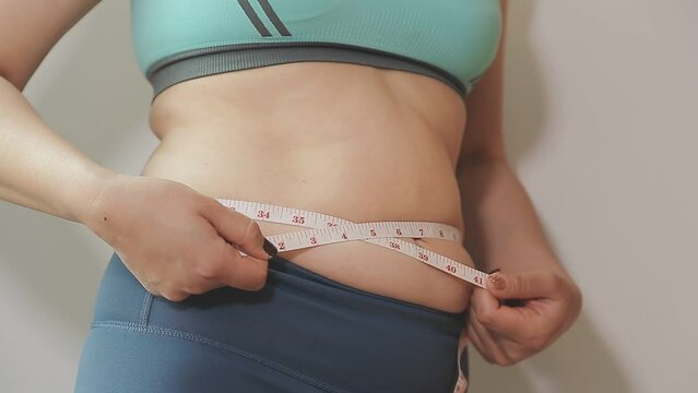 Women body fat belly. Obese woman hand holding excessive belly fat. diet lifestyle concept to reduce belly and shape up healthy stomach muscle.
