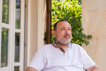 Middle-age man in a white shirt relaxing on a summer day - portrait